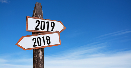 New Year wooden road sign with shining blue sky background.